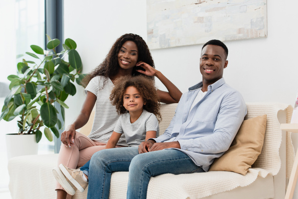 african american family sitting on sofa and looking at camera - Φωτογραφία, εικόνα