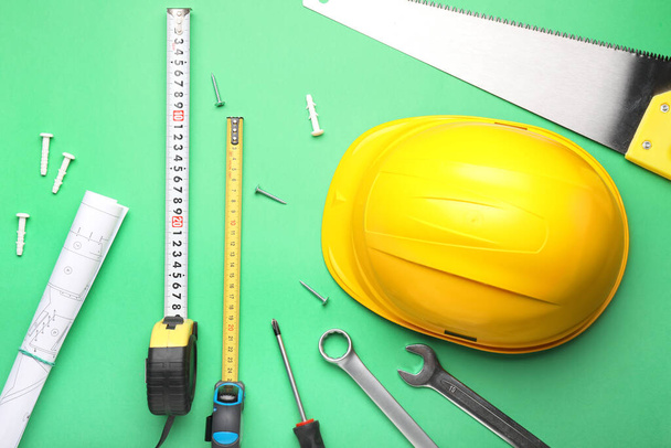 Measuring tapes with builder's supplies and blueprint on color background - Valokuva, kuva