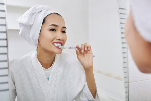 Ładna młoda Wietnamka myje zęby po porannym prysznicu - Zdjęcie, obraz