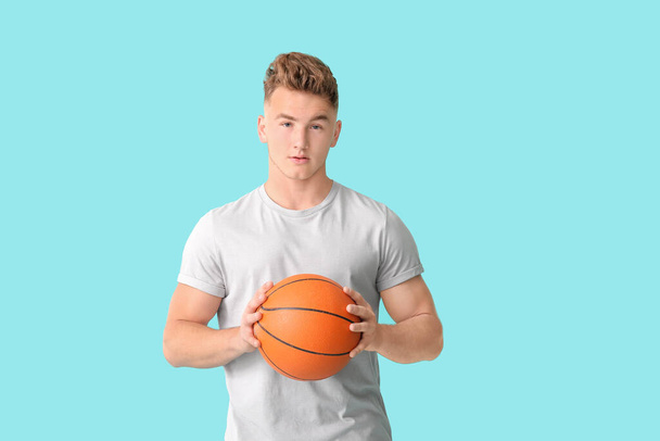Young man with ball on color background - Photo, Image