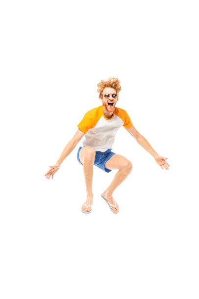 Excited man in flip flops and sunglasses jumping isolated on white - Foto, afbeelding