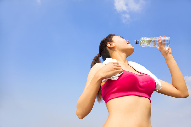 sportliche Frau trinkt Wasserflasche nach dem Joggen oder Laufen - Foto, Bild