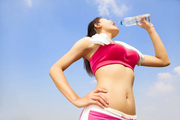 young woman drinking water after running session - Photo, Image