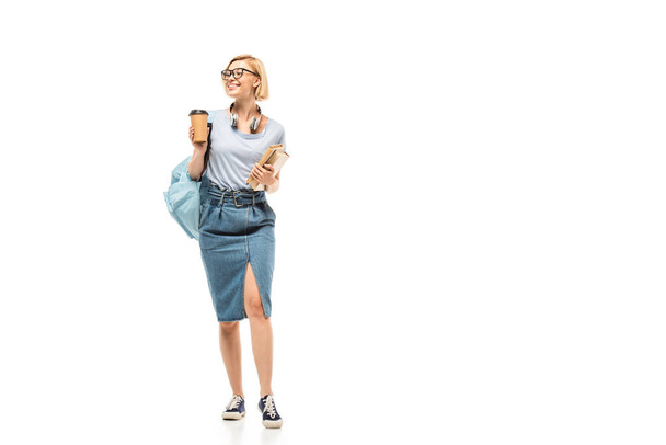 Student in headphones holding coffee to go and books on white background - Photo, Image