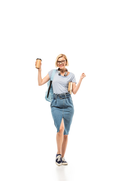Student with books and coffee to go showing yeah gesture on white background - Foto, imagen