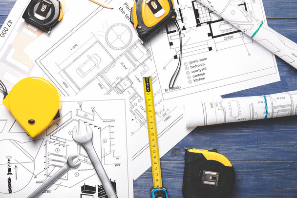 Measuring tapes with builder's supplies and blueprint on table - Foto, Imagem