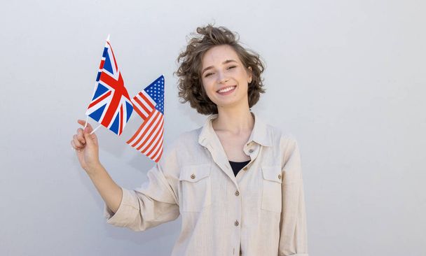 Smiling woman with flags USA and United Kingdom, countries of English language speaking. Study abroad. - Zdjęcie, obraz