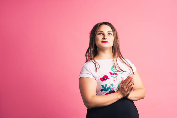 Pensive plus size model on pink background, body positive concept - Foto, afbeelding