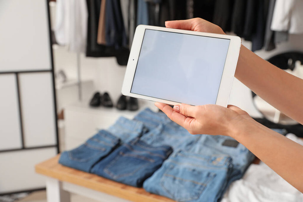 Mujer con tablet en la tienda de ropa moderna - Foto, Imagen
