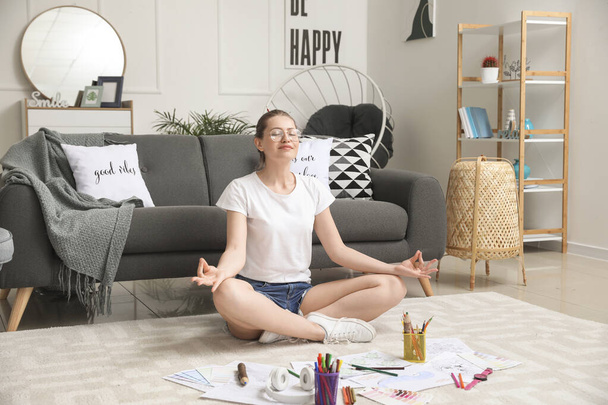 Молодая женщина медитирует во время раскрашивания картины дома - Фото, изображение