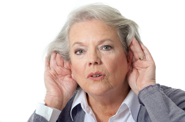 Volwassen vrouw houdt handen aan het oor - Foto, afbeelding