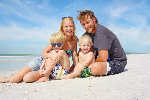 Щаслива родина з чотирьох осіб на пляжі. - Фото, зображення