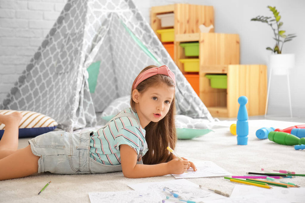 Χαριτωμένο κοριτσάκι χρωματίζοντας εικόνες στο σπίτι - Φωτογραφία, εικόνα