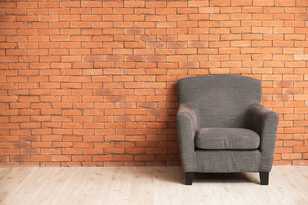 Άνετη πολυθρόνα κοντά στον τοίχο στο δωμάτιο - Φωτογραφία, εικόνα