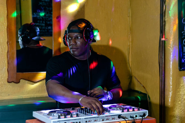 Kubański DJ-ek grający muzykę na nowoczesnym sprzęcie do miksowania gramofonów dj. - Zdjęcie, obraz