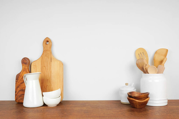 Konyhai eszközök és edények egy fa polcon vagy számlálón fehér háttérrel, fénymásoló hellyel. Házi konyha főzés dekoráció. - Fotó, kép