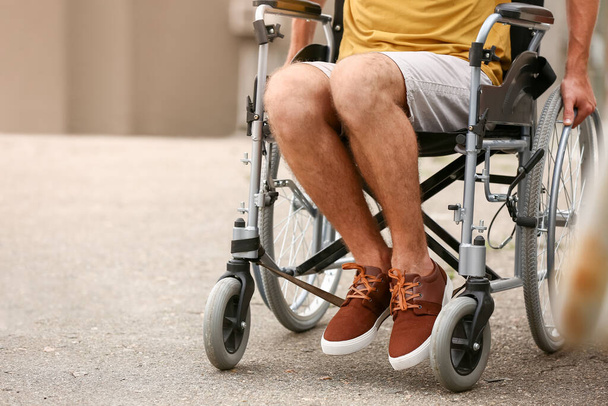 Jongeman in een rolstoel buiten - Foto, afbeelding