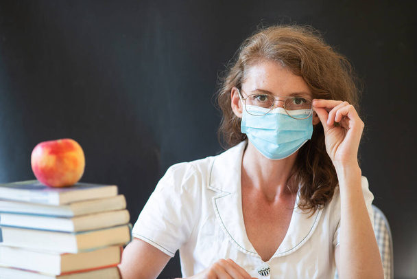 retour à l'école pendant les pandémies covid professeur avec masque facial - Photo, image