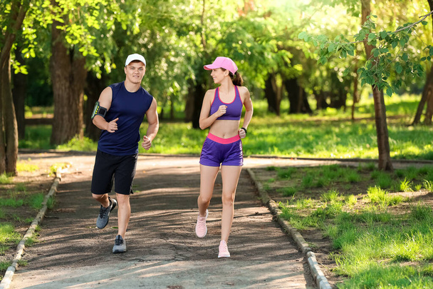 Sporty young couple running in park - Photo, Image