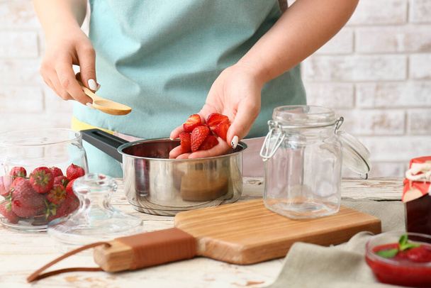 Mujer haciendo mermelada de fresa dulce en la cocina - Foto, imagen