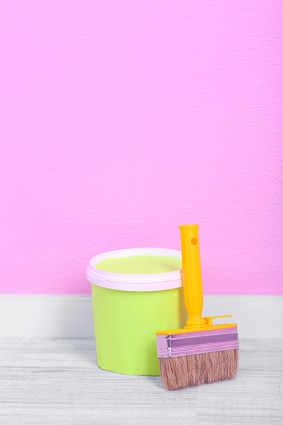 Paint and paintbrush on floor in room on wall background - Φωτογραφία, εικόνα