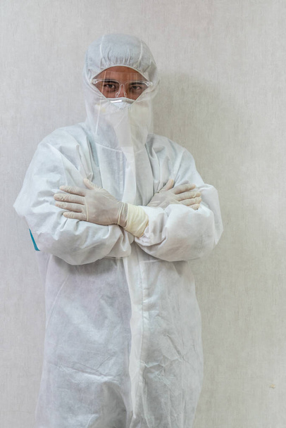 Dokter in PPE-pak, gezichtsmasker en gezichtsschild in ziekenhuisafdeling beschermd tegen Coronavirus en Covid-19 infectie . - Foto, afbeelding
