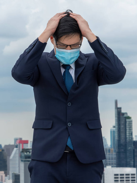 Несчастный потерянный бизнесмен в маске для лица защищен от коронавируса или Ковид-19 страдает от экономических проблем. Концепция проблемы безработицы, вызванной пандемией коронавируса Ковид-19
. - Фото, изображение