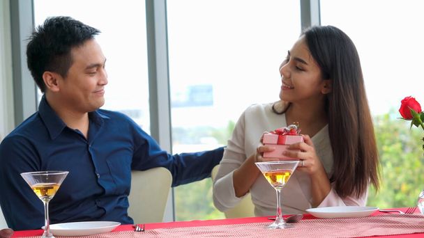 Romantic couple giving gift to lover at restaurant . Happy couple lifestyle . - Photo, Image