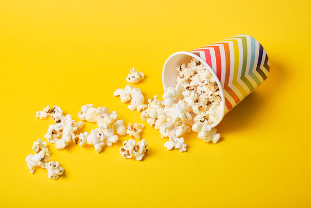 popcorn in bright holiday paper cup on yellow background - Foto, Imagen