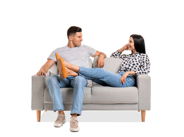 Young couple relaxing on sofa against white background - Photo, Image