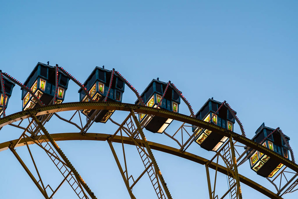 A low angle shot of a ferris wheel against a blue and clear sky - Φωτογραφία, εικόνα