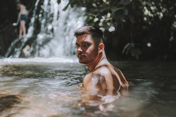 A young male relaxing near the Hueznar waterfall in the Sierra Norte natural park in Spain - 写真・画像
