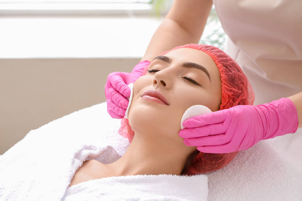 Young woman undergoing treatment in beauty salon - Foto, Imagen