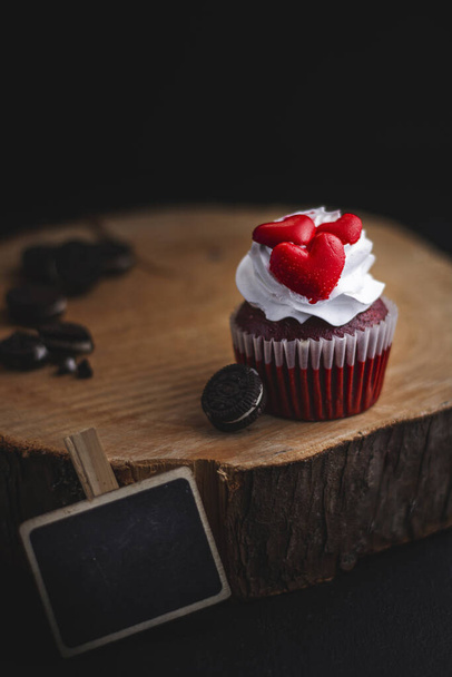 A vertical shot of a cupcake decorated with red hearts - Foto, Imagen