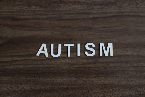 a palavra autismo soletrado em um fundo de madeira. Foto de alta qualidade - Foto, Imagem