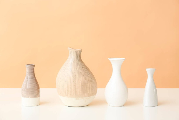 Beautiful vases on table against color background - Фото, зображення