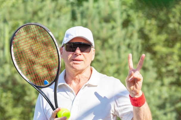 The tennis player shows the victory symbol with his hand - Photo, Image