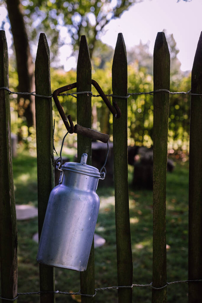 Mléčná konvice zavěšená na dřevěném plotě - Fotografie, Obrázek