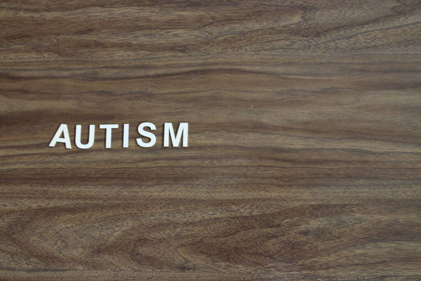 the word autism spelled out on a wooden background. High quality photo - Fotó, kép