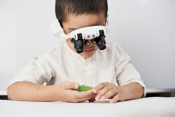 A boy wearing head magnifying glasses - Fotó, kép