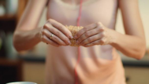 Vrouw handen dompelen croissant in koffie. Brunette geniet van het ontbijt. - Foto, afbeelding