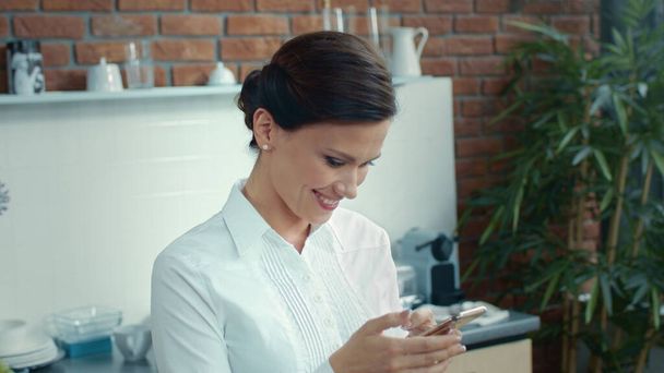 Romantic woman texting message on phone. Joyful girl checking phone content. - Фото, зображення
