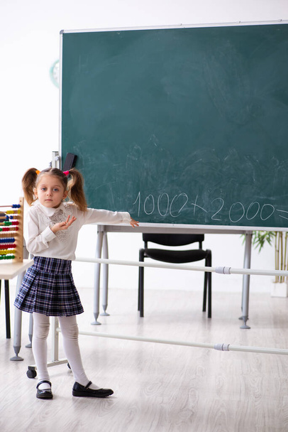 Pieni tyttö edessä liitutaulu luokkahuoneessa - Valokuva, kuva