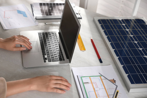Woman working on house project with solar panels at table in office, closeup - Photo, Image