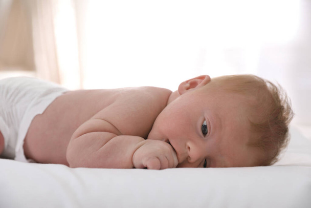 Cute little baby lying on bed at home - Fotografie, Obrázek