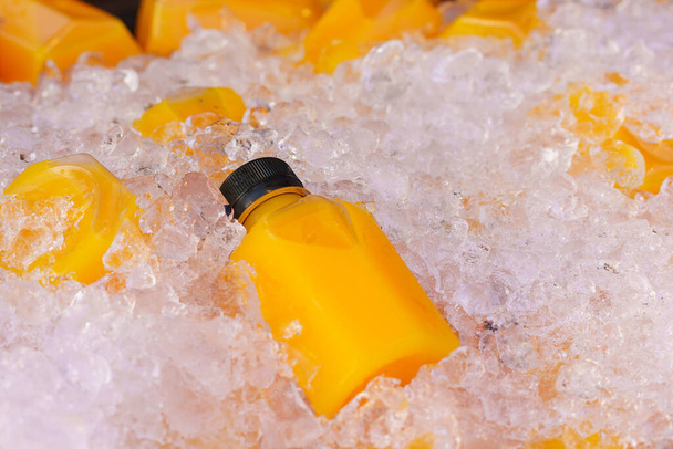 Orange juice bottles on ice box for healthy drink. - Photo, Image