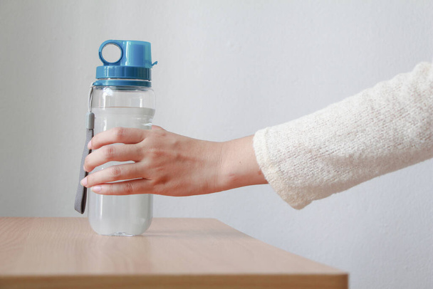 Frau in der Hand einer Flasche Wasser. - Foto, Bild