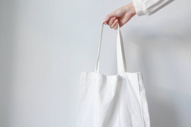 Mujer sosteniendo bolsa de lona sobre fondo blanco. Bolsa Eco reutilizable. Concepto ecológico. - Foto, imagen