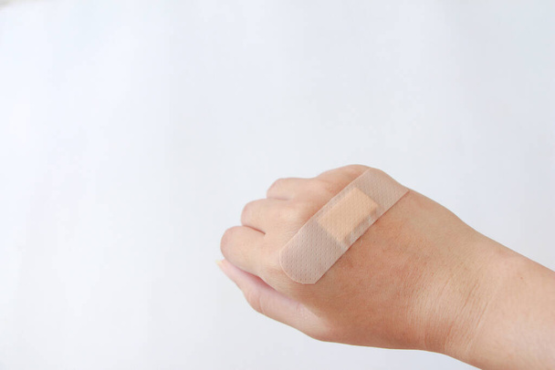 Молодая женщина повредила указатель задней руки и использовала пластырь для скорой помощи. - Фото, изображение