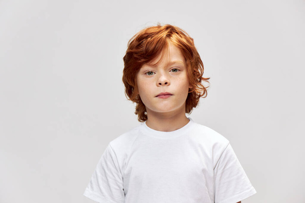 灰色の背景に赤い髪の子供の肖像白いTシャツクロップドスタジオ - 写真・画像
